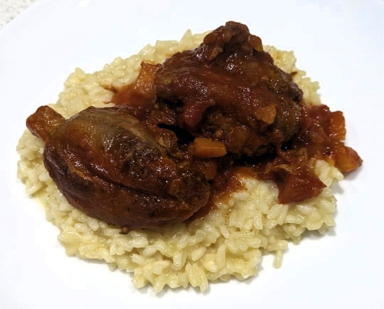 Lamb with Red Sauce sitting on a bed of risotto rice