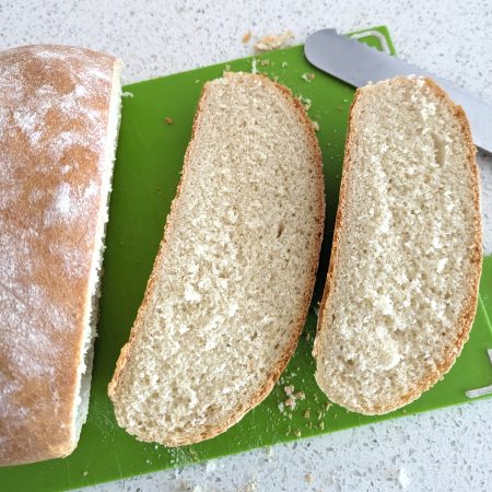 Homemade Village Bread / Baked Bread Slices on Chopping Board