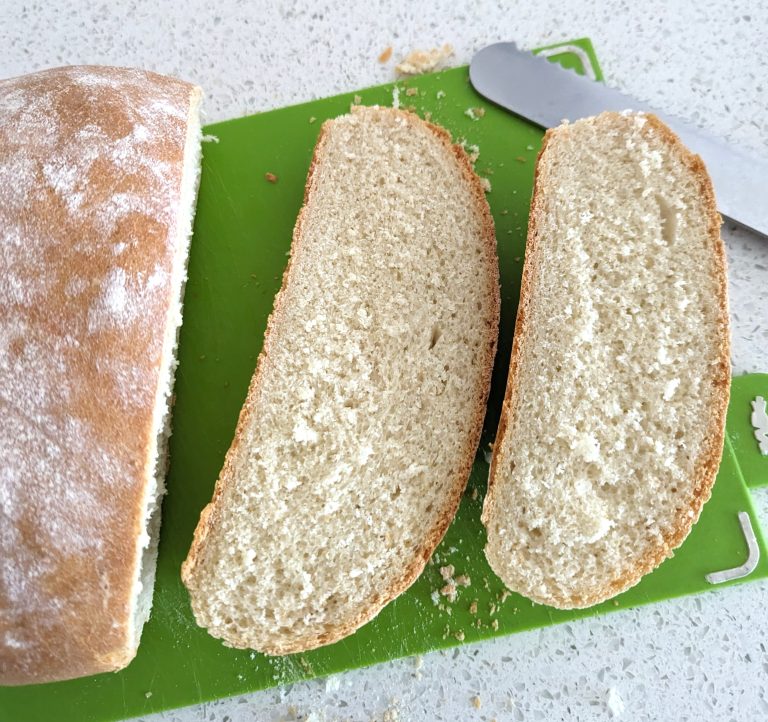 Homemade Village Bread / Baked Bread Slices on Chopping Board