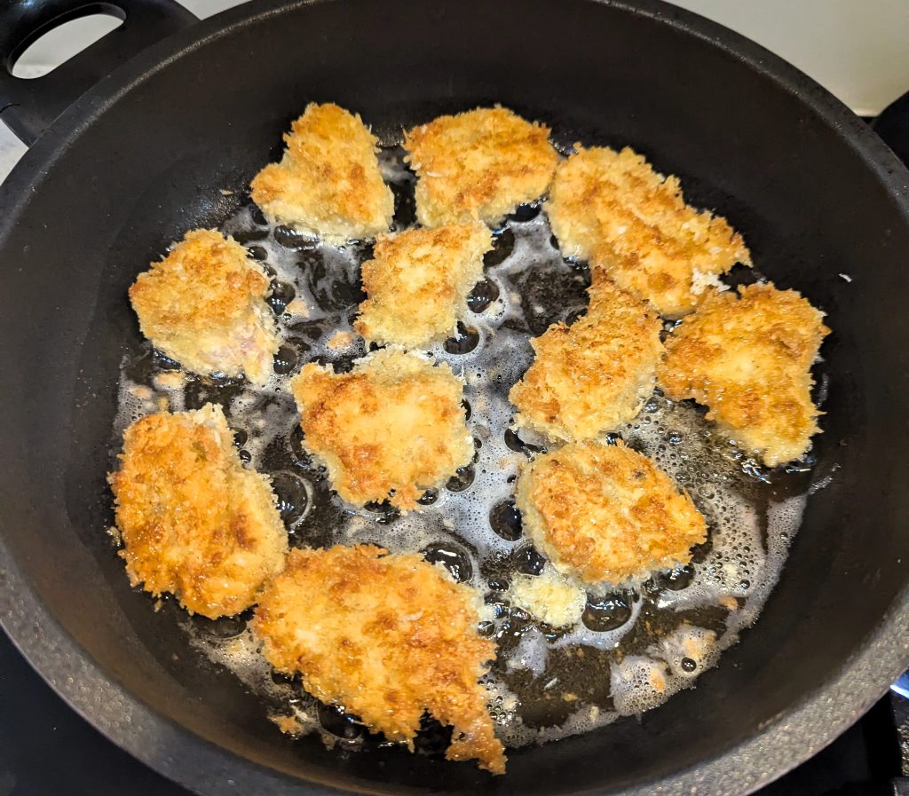 Chicken nuggets frying in a pan