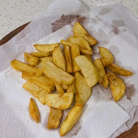 a pile of french fries on a paper towel