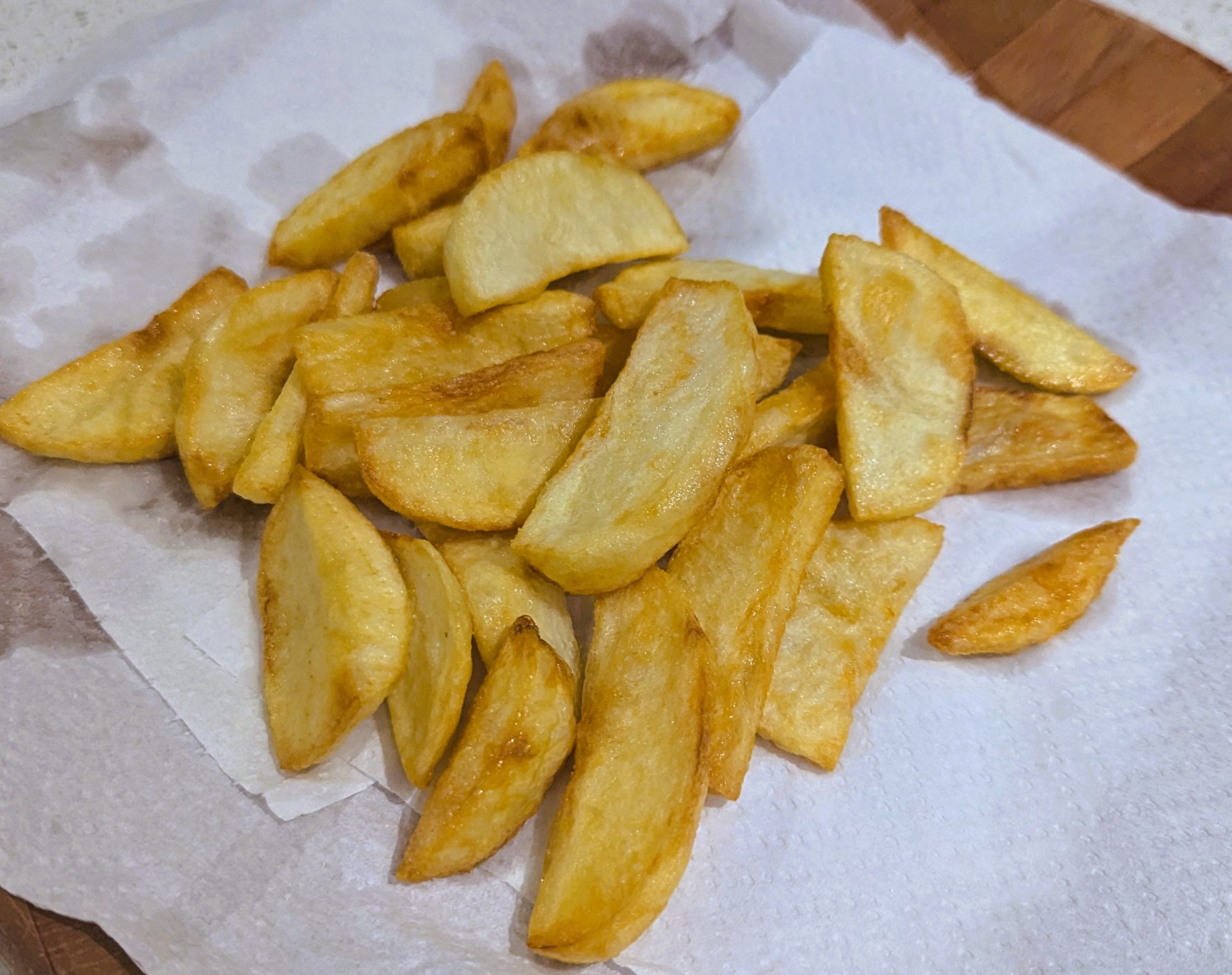 a pile of french fries / patates tiganites on a paper towel